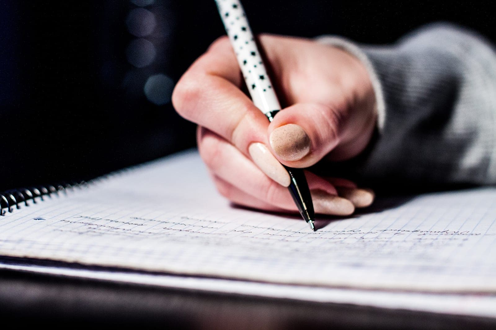GR Stories | Close-up of a hand writing notes in a spiral notebook
