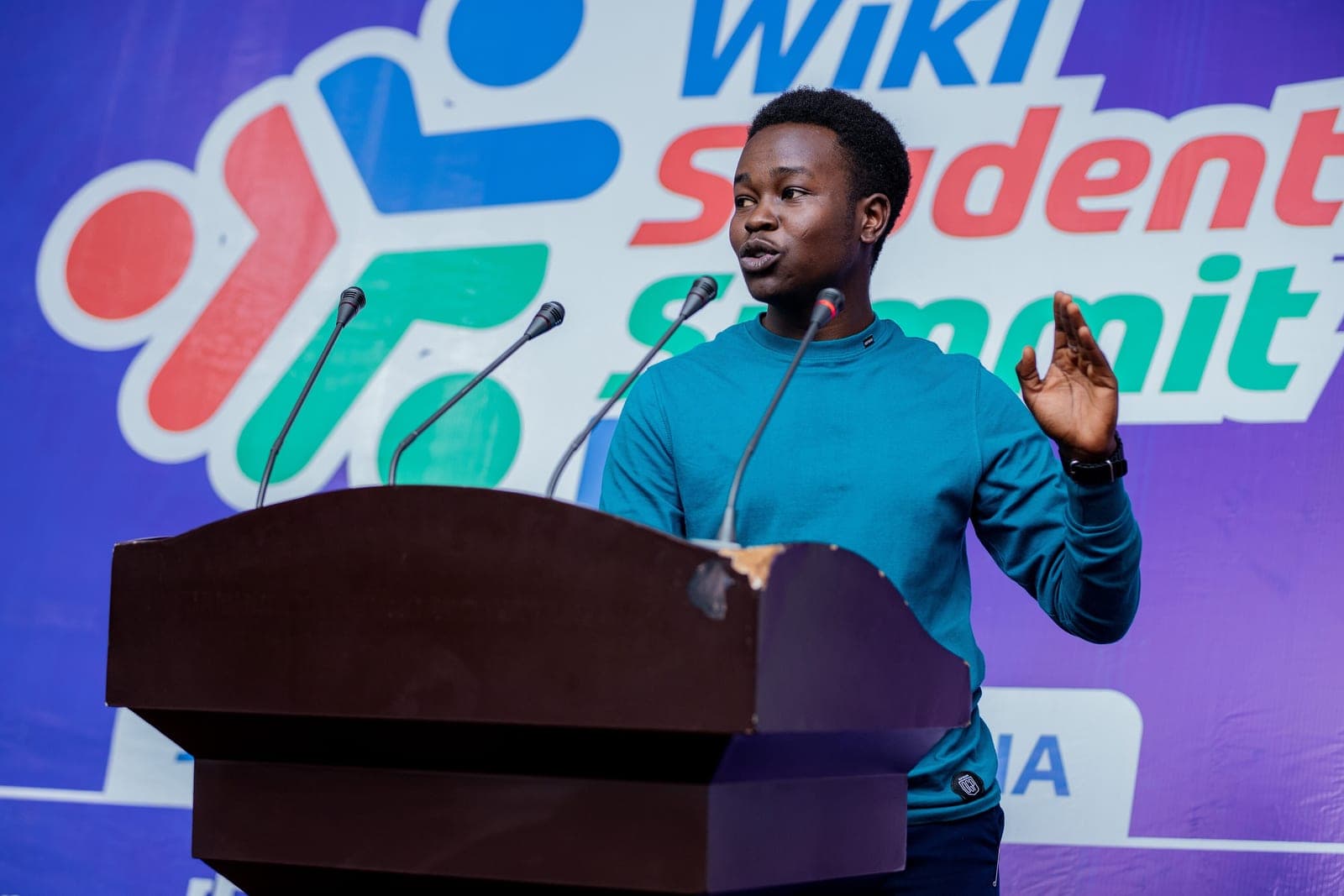 GR Stories | A student speaking at a podium in front of microphones