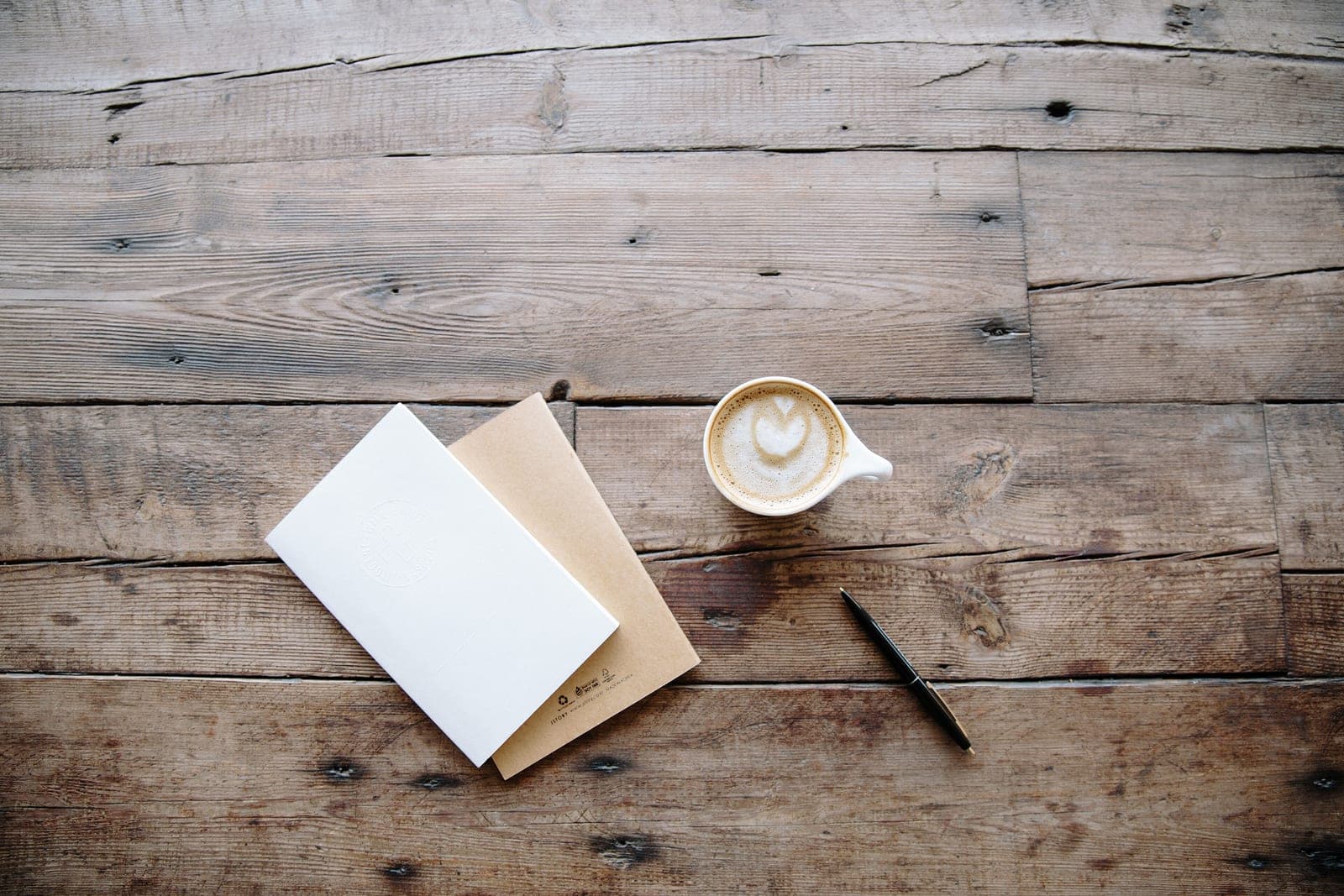 GR Stories | Notebooks, a pen and a coffee on a wooden table