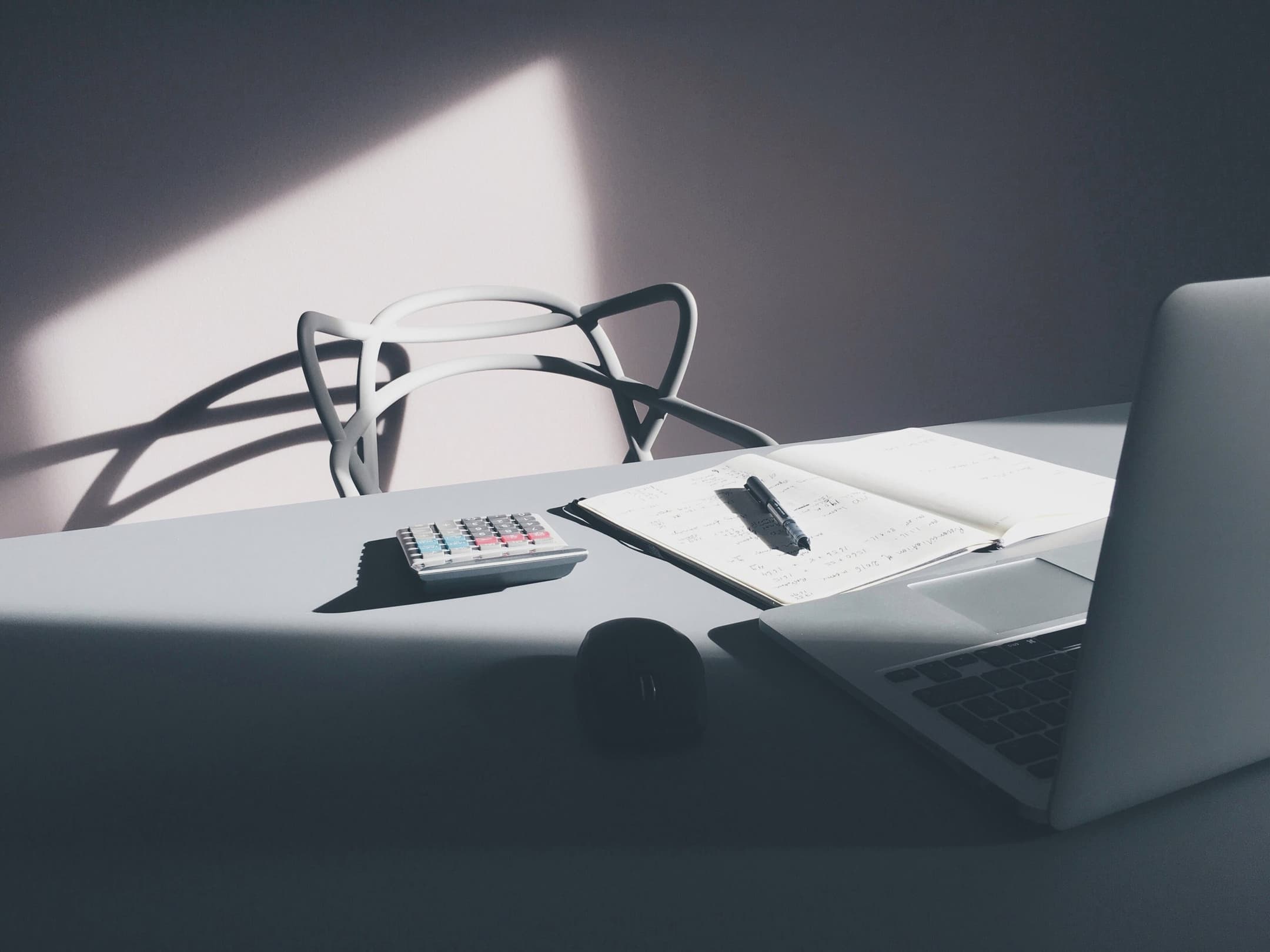 GR Stories | A desk with a laptop, a calculator and a notebook