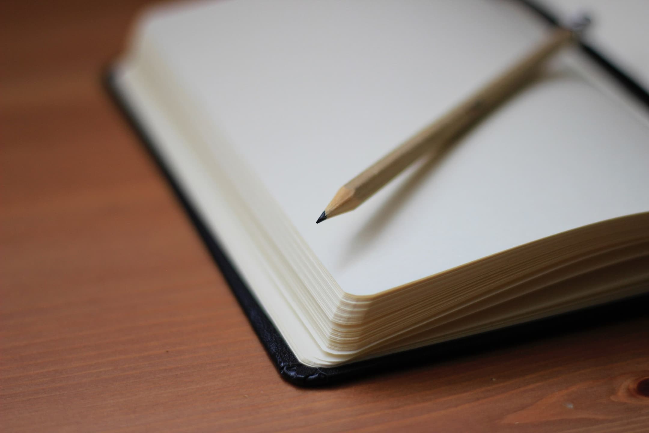 GR Stories | An open notebook with a pencil resting on the blank page