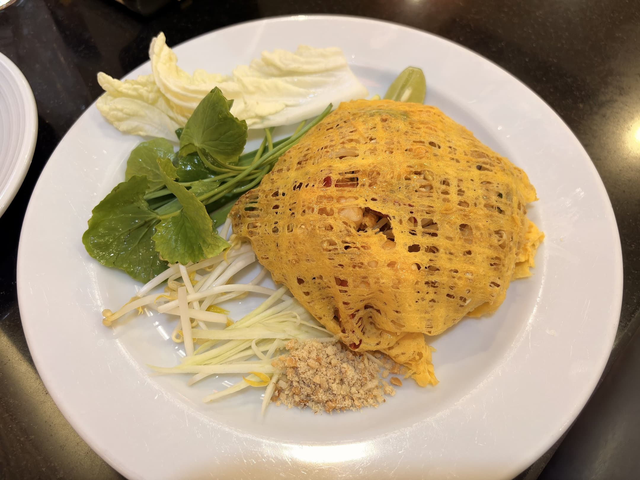 GR Stories | Pad thai wrapped in a lacy omelette, served with fresh vegetables and crushed peanuts